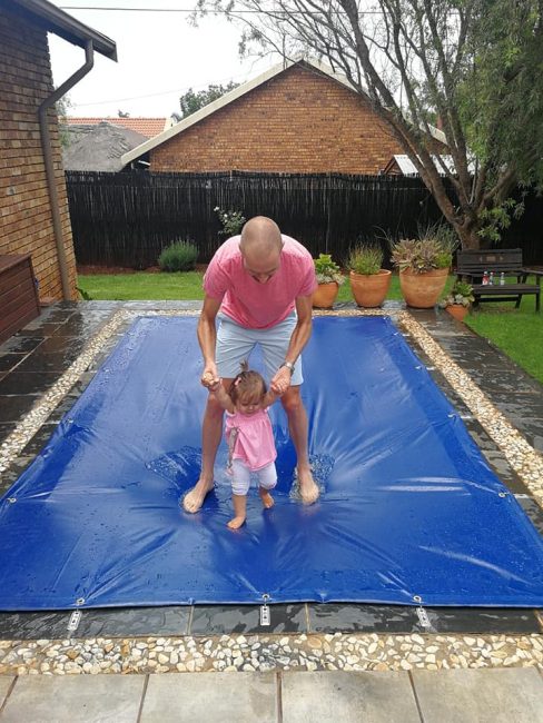happy family standing on a pool cover