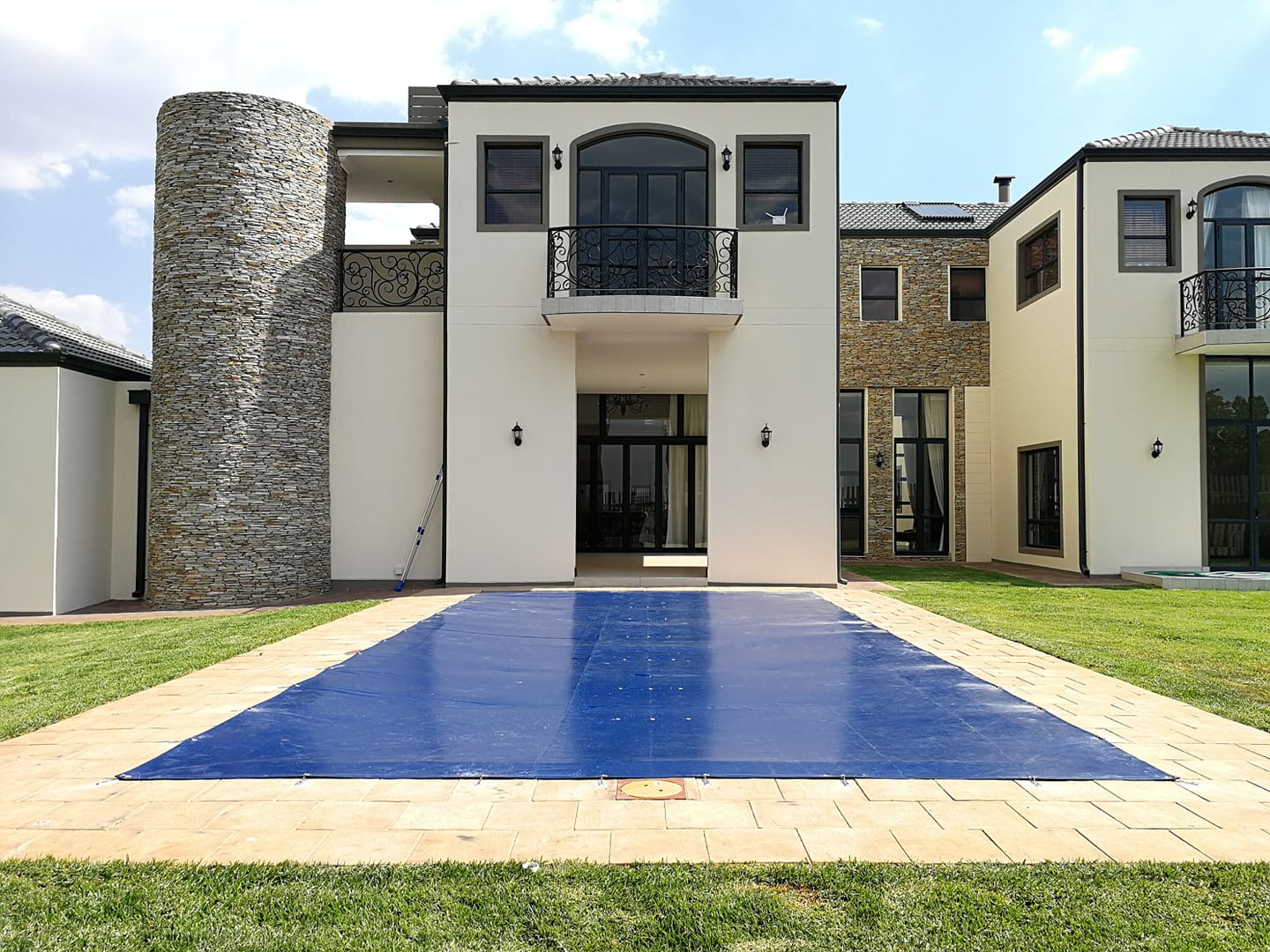 Swimming pool safety cover in front of a house